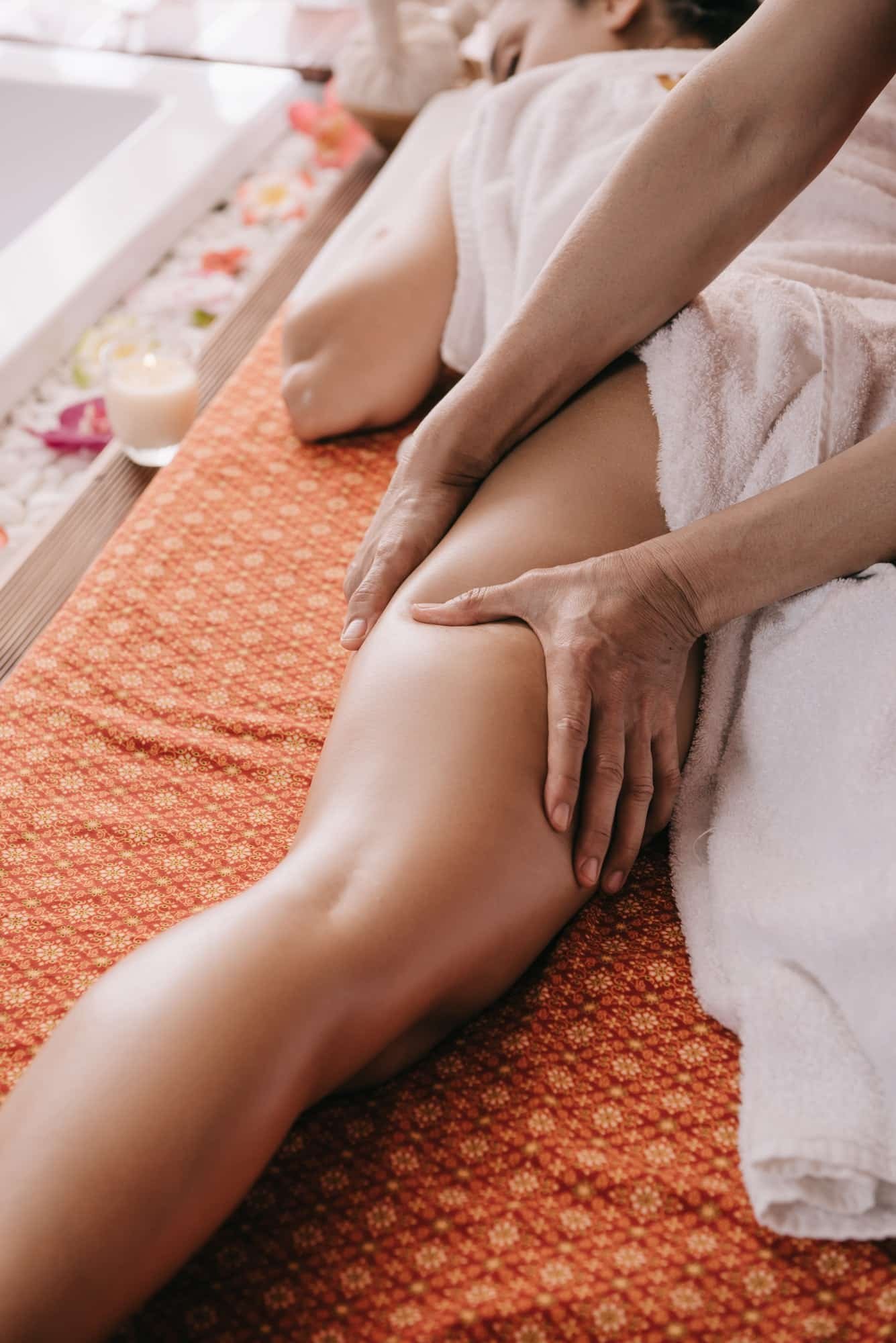 cropped view of masseur doing foot massage to woman in spa salon